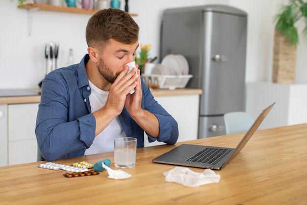 Homme travaillant sur la vue latérale d'un ordinateur portable