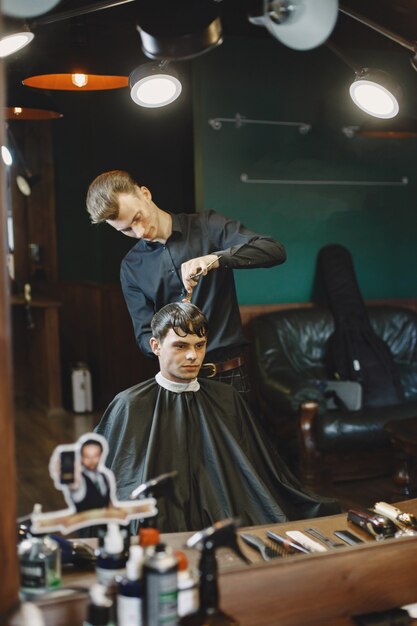 L'homme travaille avec les cheveux. Coiffeur avec un client.