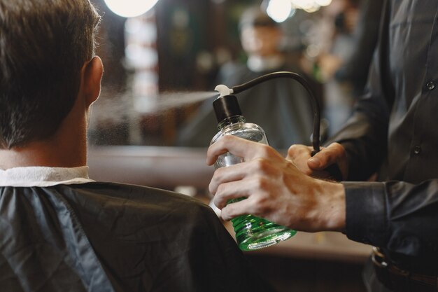 L'homme travaille avec les cheveux. Coiffeur avec un client.