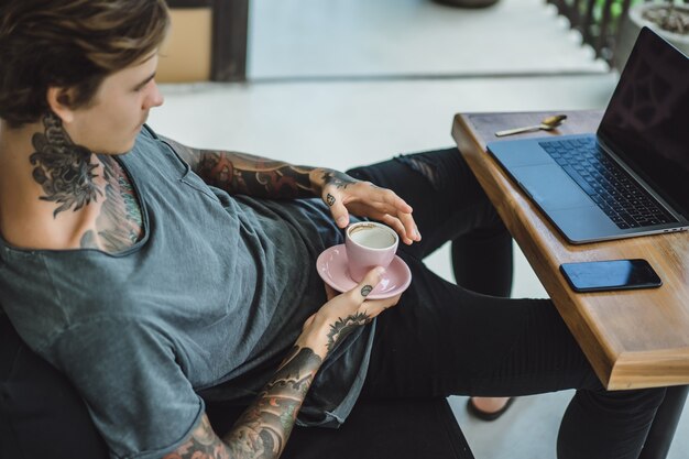 l&#39;homme travaille dans un café. concept de freelance, café et ordinateur portable