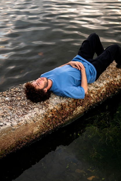 Photo gratuite homme triste et contemplatif assis au bord du lac