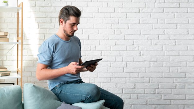 Homme utilisant un assistant numérique sur sa tablette