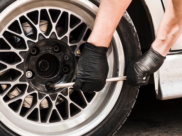 Homme utilisant une clé pour serrer les écrous de roue