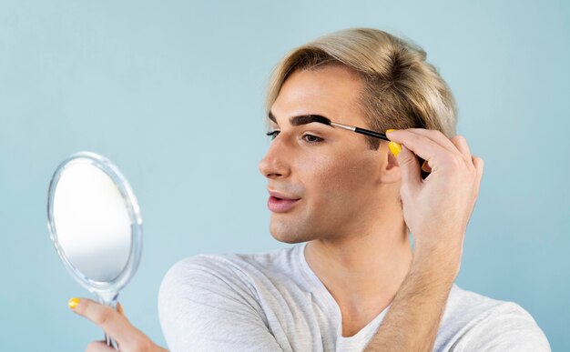 Homme utilisant des cosmétiques de maquillage