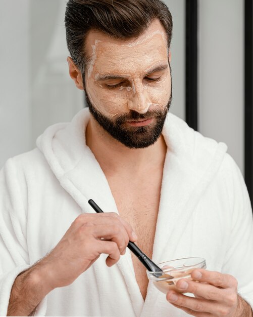 Homme utilisant des ingrédients naturels pour un masque facial