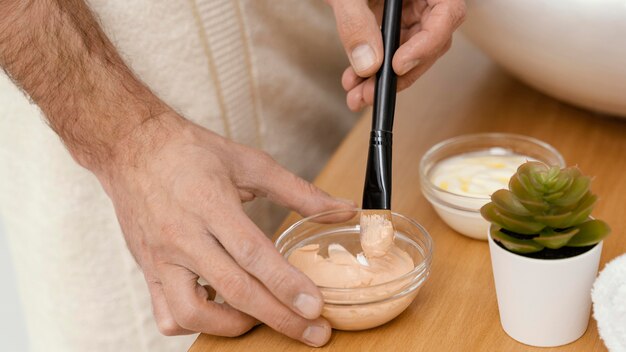 Homme utilisant des ingrédients naturels pour un masque facial