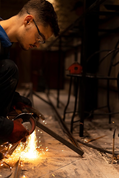 Homme utilisant une meuleuse d'angle avec des étincelles