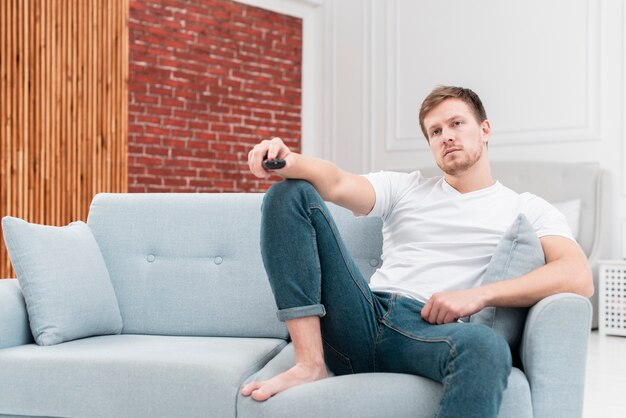 Homme utilisant la télécommande pour changer de chaîne