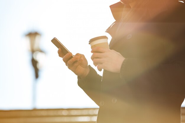 Homme, utilisation, téléphone portable, et, café buvant, dehors, dans, jour ensoleillé