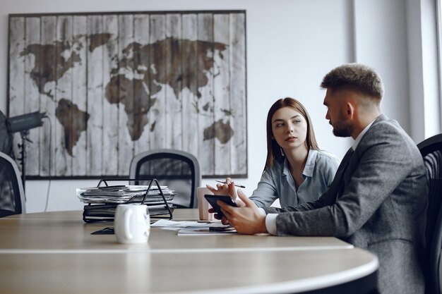 L'homme utilise une tablette. Partenaires commerciaux lors d'une réunion d'affaires.Les gens sont assis à la table