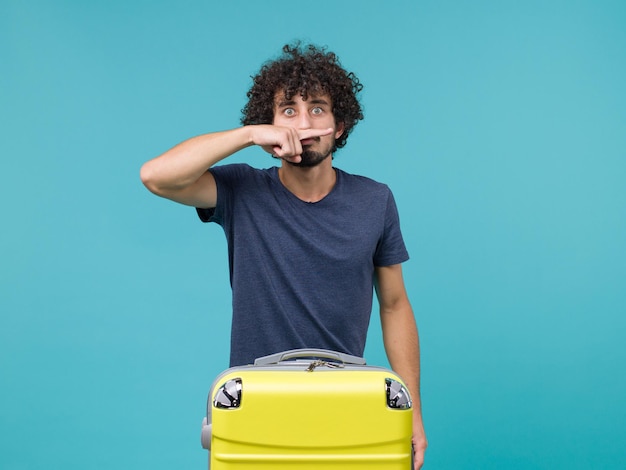 homme en vacances en t-shirt bleu posant sur bleu