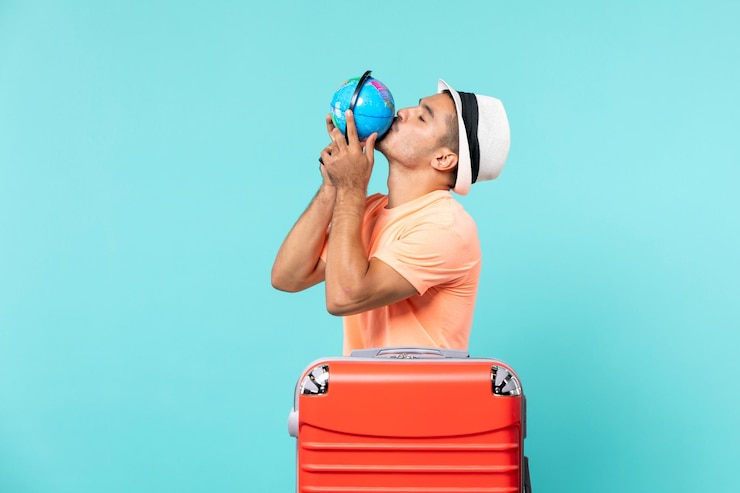 Photo gratuit homme en vacances tenant un petit globe sur bleu