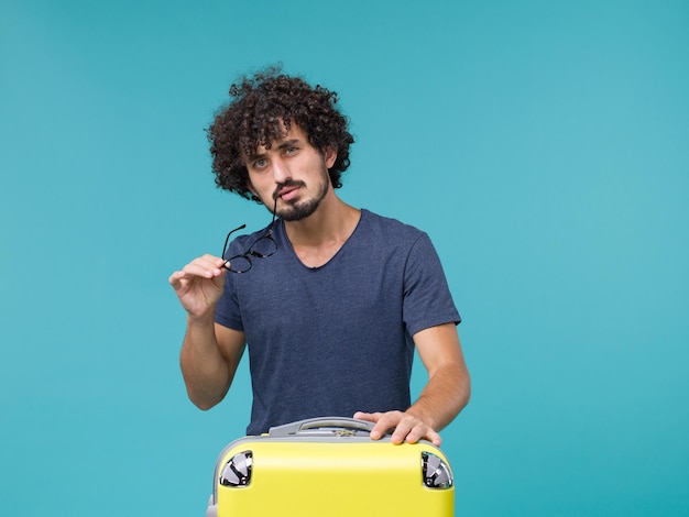 Homme En Vacances Tenant Ses Lunettes De Soleil Avec Valise Sur Bleu