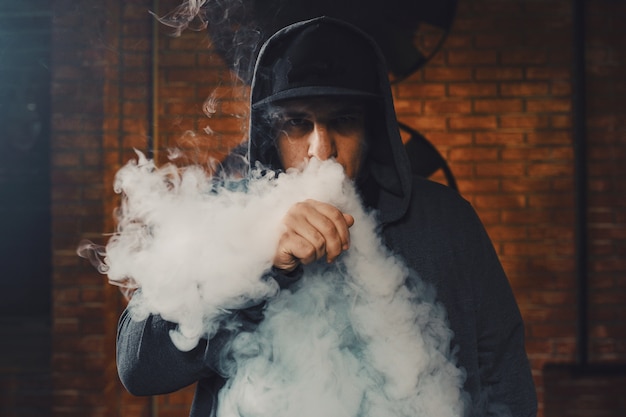 Photo gratuite homme vaping une cigarette électronique