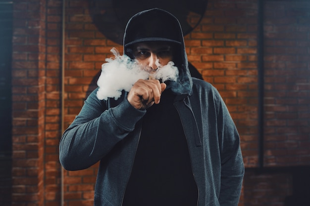 Photo gratuite homme vaping une cigarette électronique