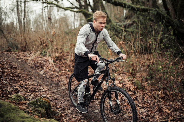 Homme à vélo dans la forêt pendant l&#39;automne