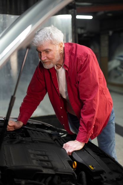 Homme vérifiant le moteur de la voiture