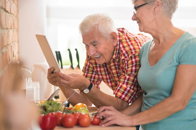 Photo gratuite homme vérifiant la recette sur la tablette