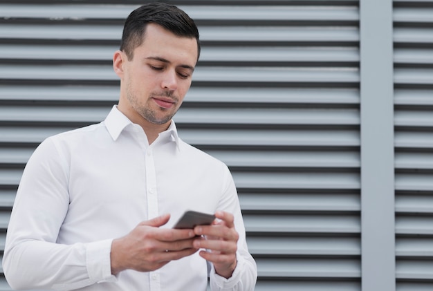 Homme vérifiant téléphone coup moyen