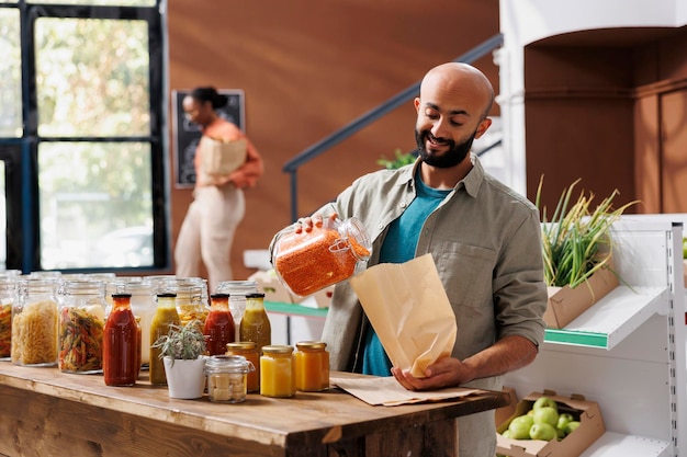 Photo gratuite un homme verse des lentilles orange dans un sac.