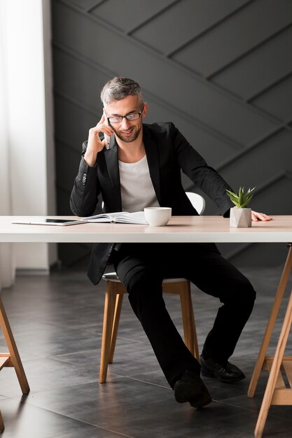 Homme, à, veste noire, conversation téléphone, intérieur