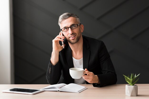 Homme, à, veste noire, regarder loin, et, tenue, a, tasse