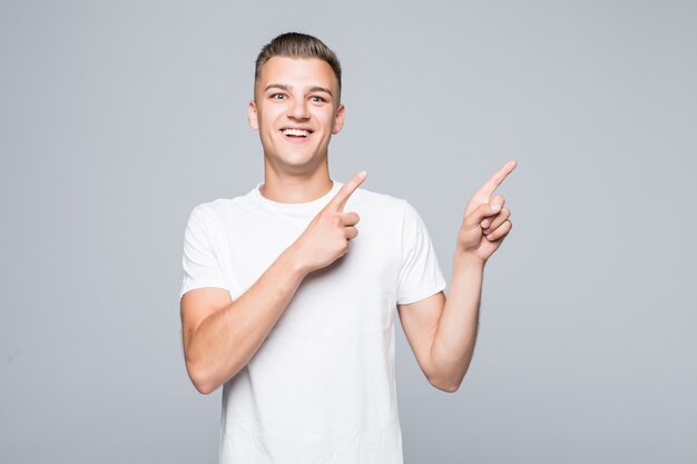 L'homme en vêtements blancs pointe sur quelque chose avec les deux mains les doigts isolés sur blanc