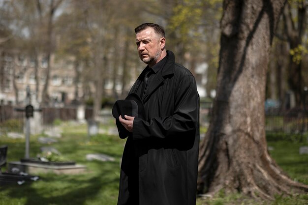 Homme visitant la pierre tombale au cimetière