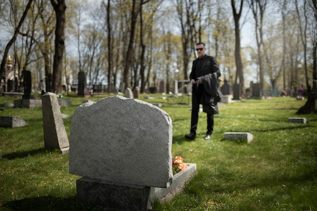 Homme visitant la pierre tombale au cimetière