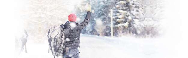 Un homme voyage avec un sac à dos. randonnée hivernale en forêt. touriste en promenade en hiver dans le parc.