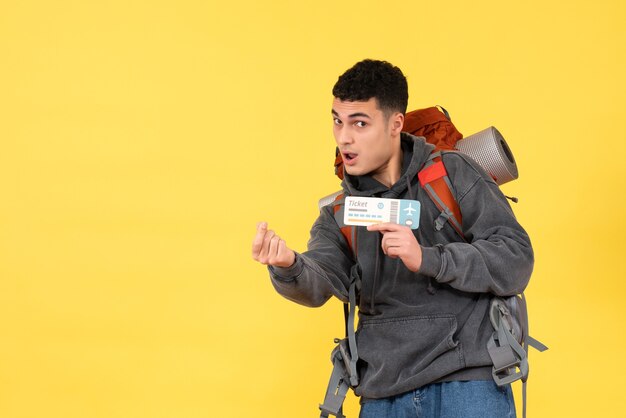 Homme de voyageur cool vue de face avec sac à dos rouge tenant un billet de voyage