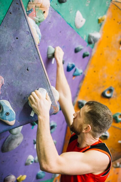 Homme de vue de côté accroché sur le rebord du mur