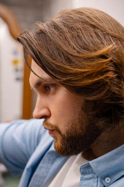 Homme vue de côté au salon de coiffure