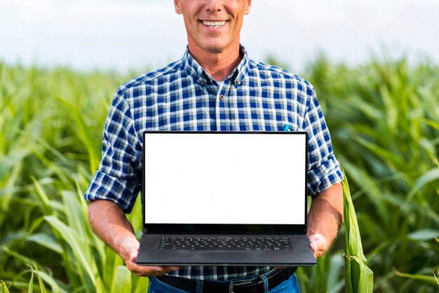 Homme vue du milieu tenant une maquette d'ordinateur portable