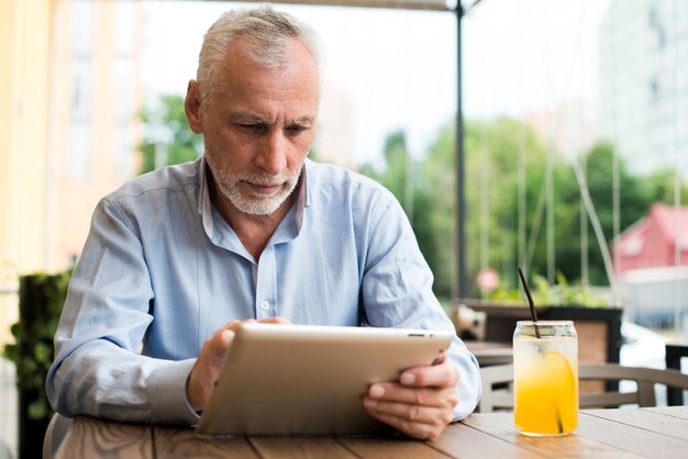 Homme vue de face en regardant une tablette