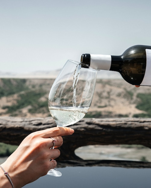 Un homme vue de face versant du vin dans le verre des femmes sur la vue sur la ville de l'alcool personnes humaines vin