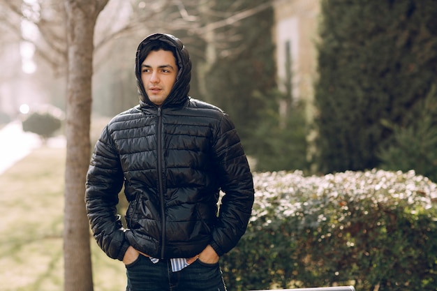 Photo gratuite homme zippant la veste en cuir noir jusqu'au bout et portant le sweat à capuche pour éviter le froid. photo de haute qualité