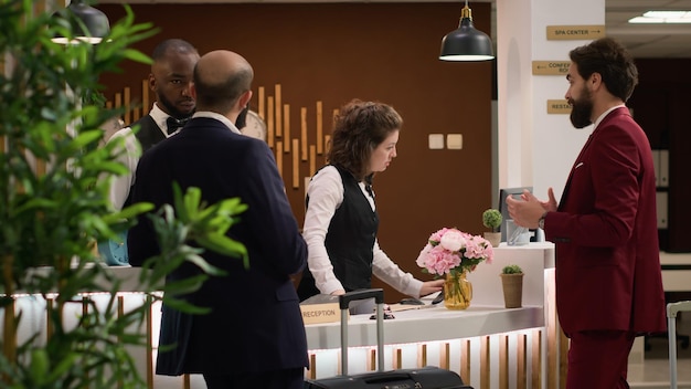 Photo gratuite des hommes d'affaires entrent à la réception de l'hôtel.