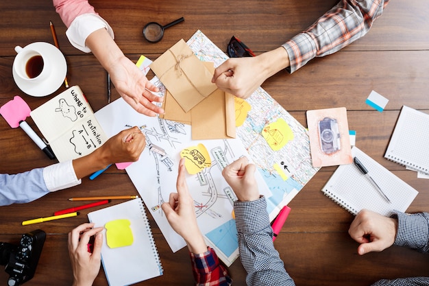 hommes d'affaires mains sur table en bois avec documents et projets