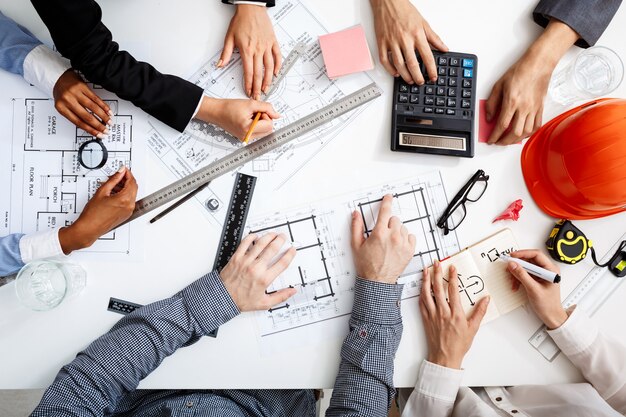 hommes d'affaires mains sur tableau blanc avec des documents et des projets