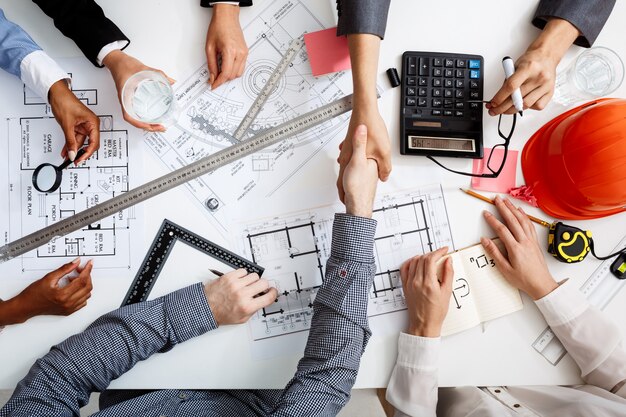 hommes d'affaires mains sur tableau blanc avec des documents et des projets
