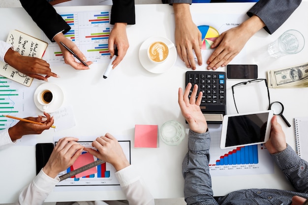 hommes d'affaires mains sur tableau blanc avec des documents et des projets