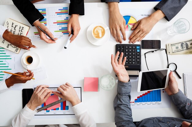 hommes d'affaires mains sur tableau blanc avec des documents et des projets