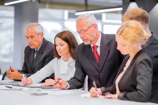 Photo gratuite hommes d'affaires sérieux travaillant sur un projet sur un bureau dans le bureau