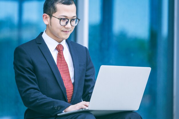 Les hommes d&#39;affaires utilisent des ordinateurs portables à l&#39;entrée d&#39;un immeuble de bureaux