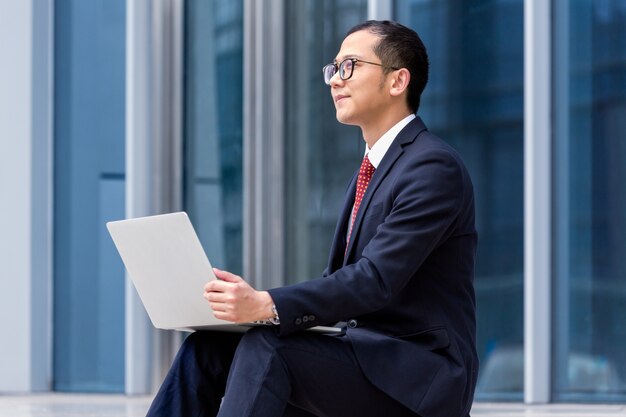 Les hommes d&#39;affaires utilisent des ordinateurs portables à l&#39;entrée d&#39;un immeuble de bureaux