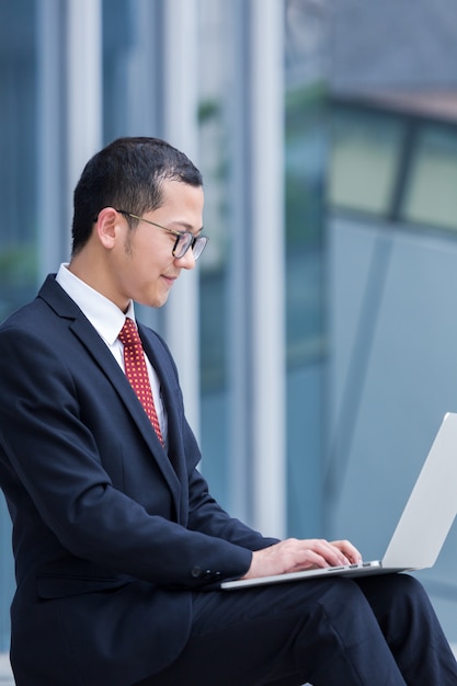 Les hommes d&#39;affaires utilisent des ordinateurs portables à l&#39;entrée d&#39;un immeuble de bureaux