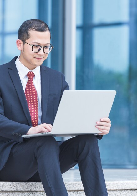 Les hommes d&#39;affaires utilisent des ordinateurs portables à l&#39;entrée d&#39;un immeuble de bureaux