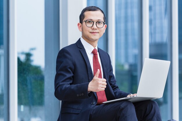 Les hommes d&#39;affaires utilisent des ordinateurs portables à l&#39;entrée d&#39;un immeuble de bureaux