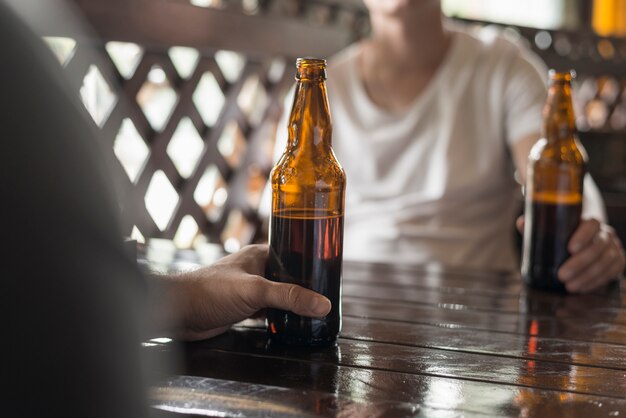 Hommes anonymes avec de la bière à table